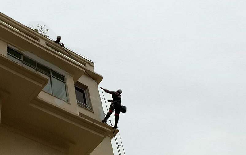 alpinistas industriais no topo do prédio demostra como fazer a limpeza da fachada